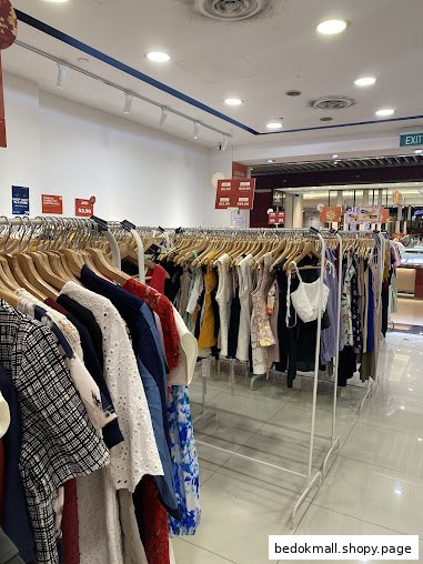 Interior view of a clothing shop with multiple racks of garments for sale.