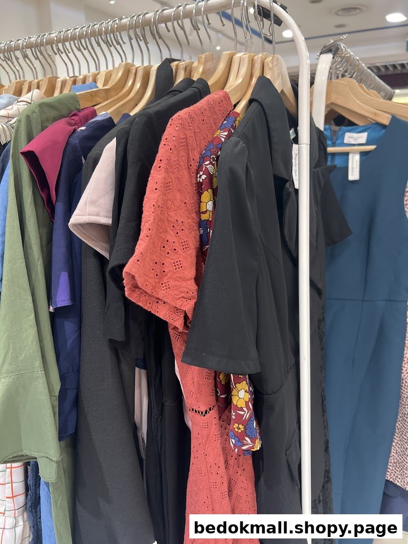 Various clothes hanging on a retail display rack inside a shop.