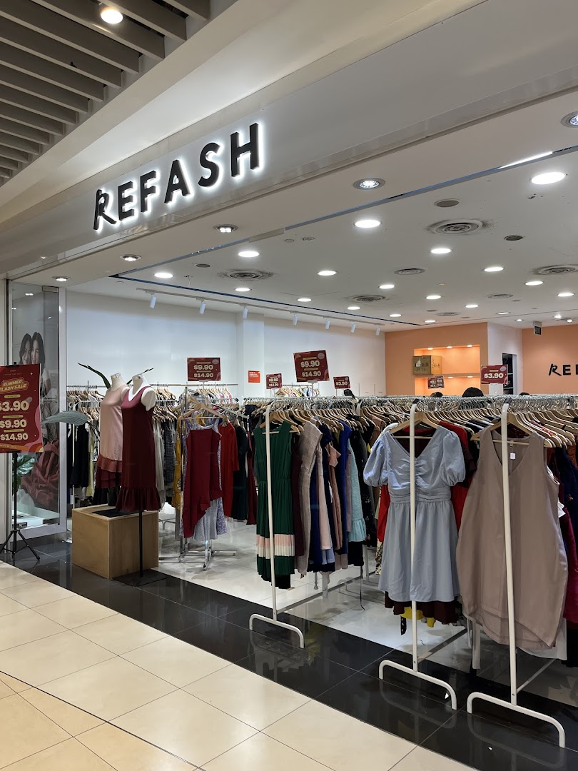Shop entrance with REFASH sign and clothing racks extending into the mall.