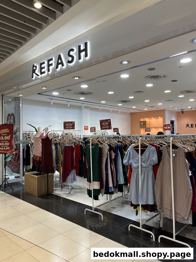 Shop entrance with REFASH sign and clothing racks extending into the mall.
