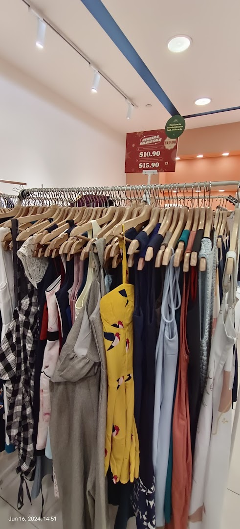 Clothing rack with various garments and a sale sign in a retail store.