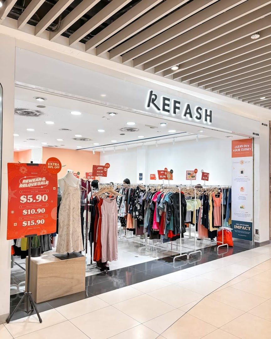 Exterior view of REFASH clothing store entrance with sale signs and clothes racks.