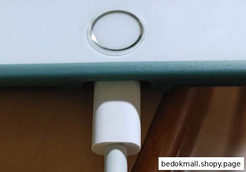 Close-up of a device with a charging cable plugged in.