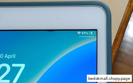 A tablet screen displays battery percentage, charging icon, and partial date.