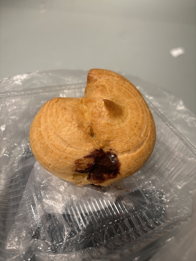 A single pastry with chocolate filling in a clear plastic container.