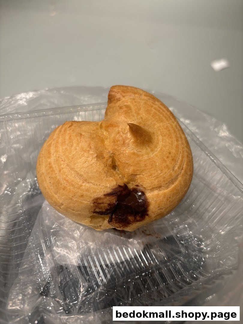 A single pastry with chocolate filling in a clear plastic container.