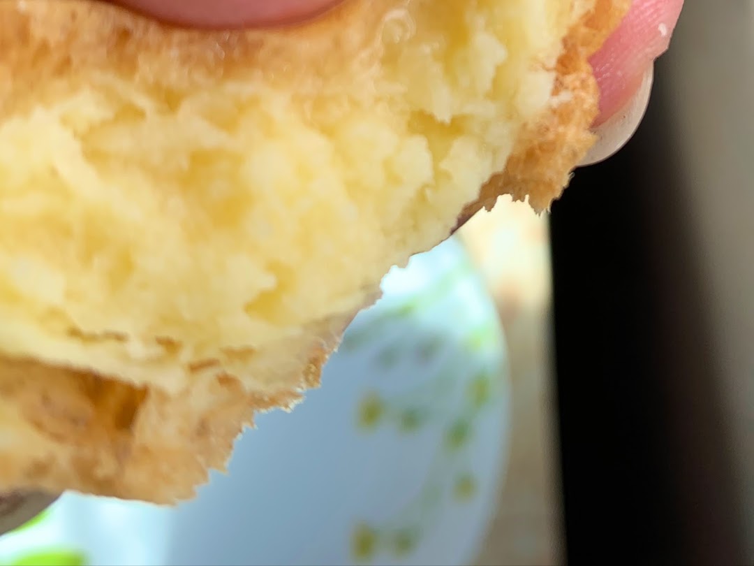 Close-up of a pastry with creamy filling being held.