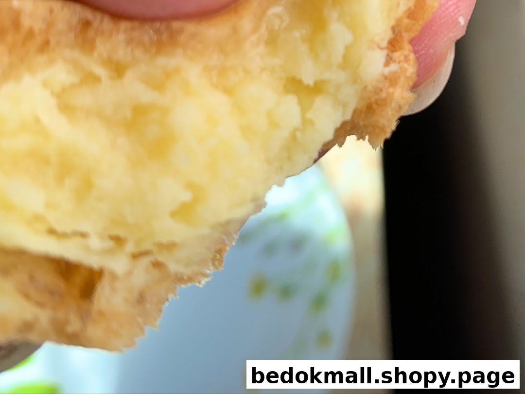 Close-up of a pastry with creamy filling being held.