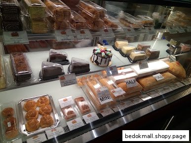 A display case filled with various pastries, cakes, and strudels.