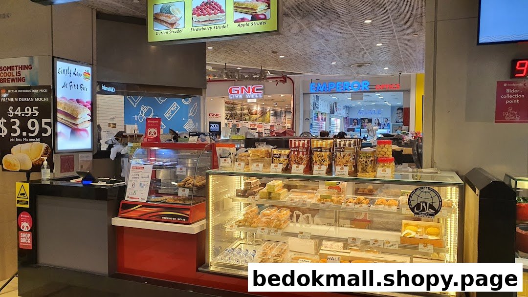 Food stall counter with display cases full of pastries and a price list.