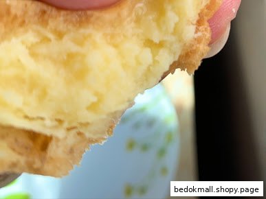 Close-up of a pastry with creamy filling being held.