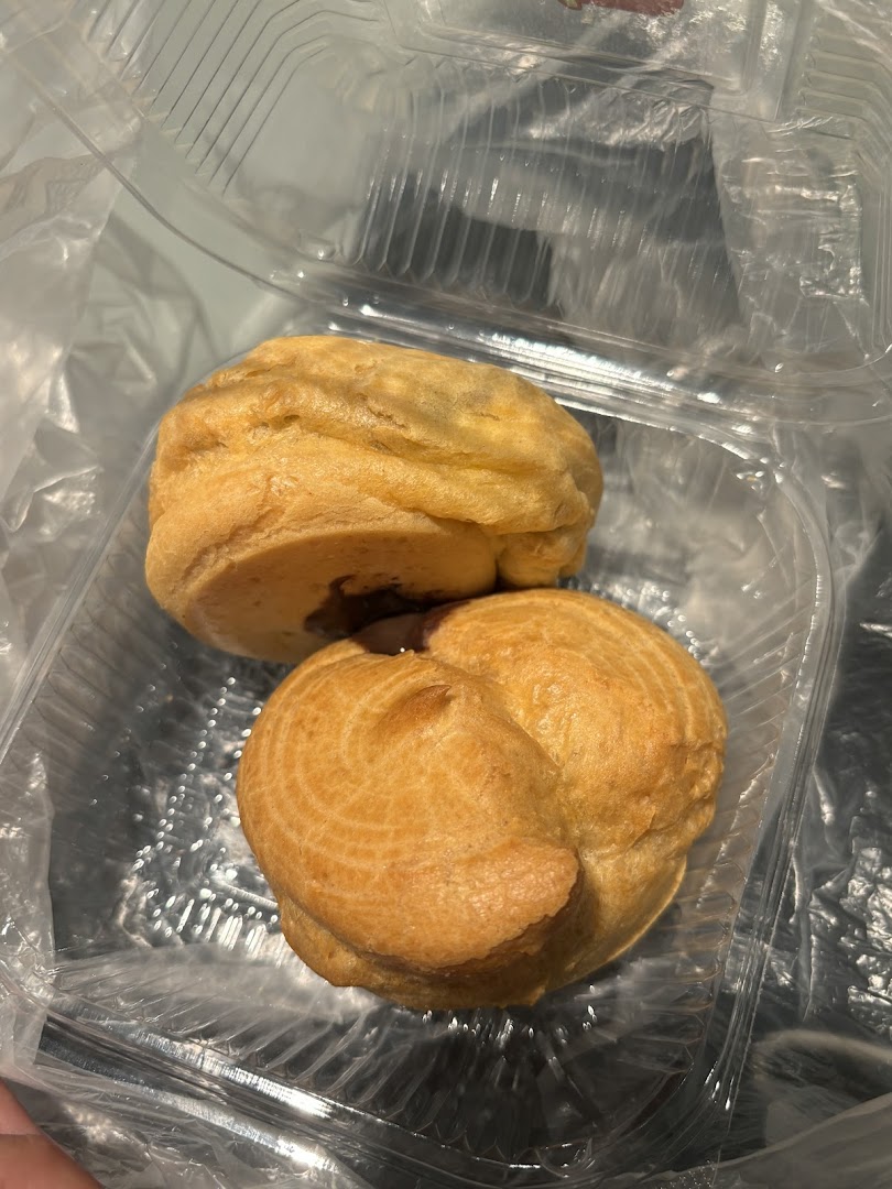 Two golden pastries in a clear plastic takeaway container.