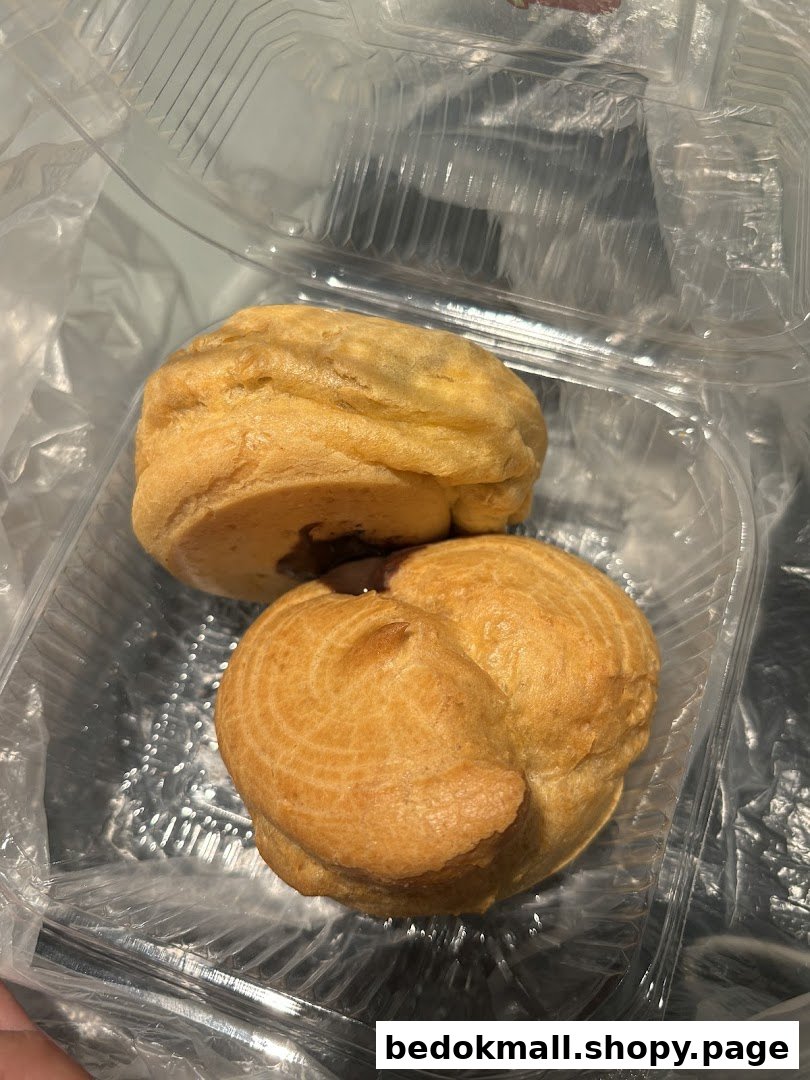 Two golden pastries in a clear plastic takeaway container.