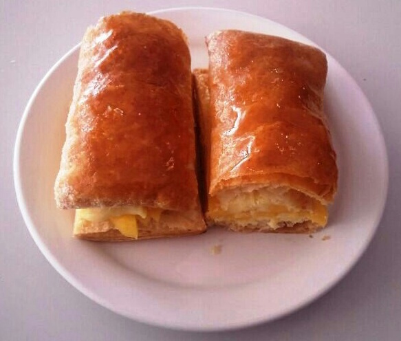Two golden-brown pastries with filling on a white plate.