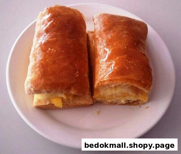 Two golden-brown pastries with filling on a white plate.