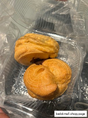 Two golden-brown pastries in a clear plastic container.