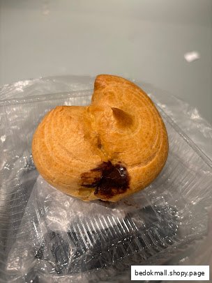 A single pastry with chocolate filling in a plastic container.