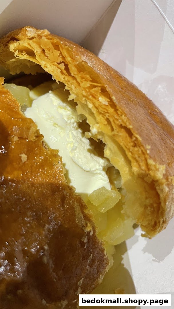 Close-up of apple strudel with cream and apple filling.