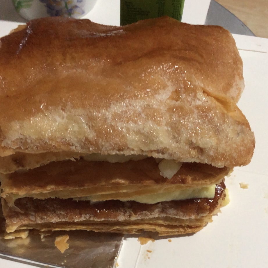 Close-up of a layered pastry with a sugary top.