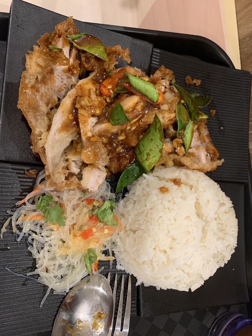 Fried chicken with rice and glass noodle salad on a black tray.