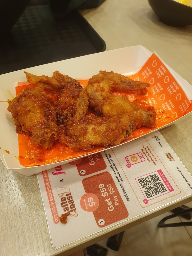 Fried chicken wings in a box on a table with a promotional placemat.