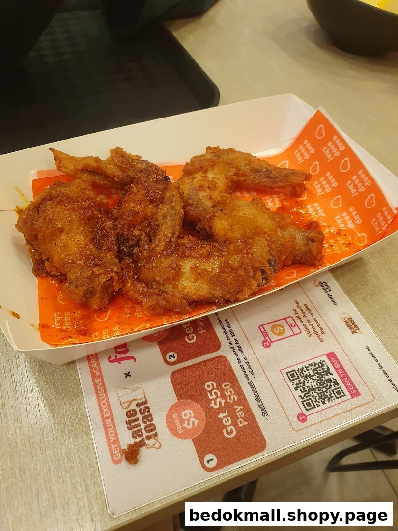 Fried chicken wings in a box on a table with a promotional placemat.