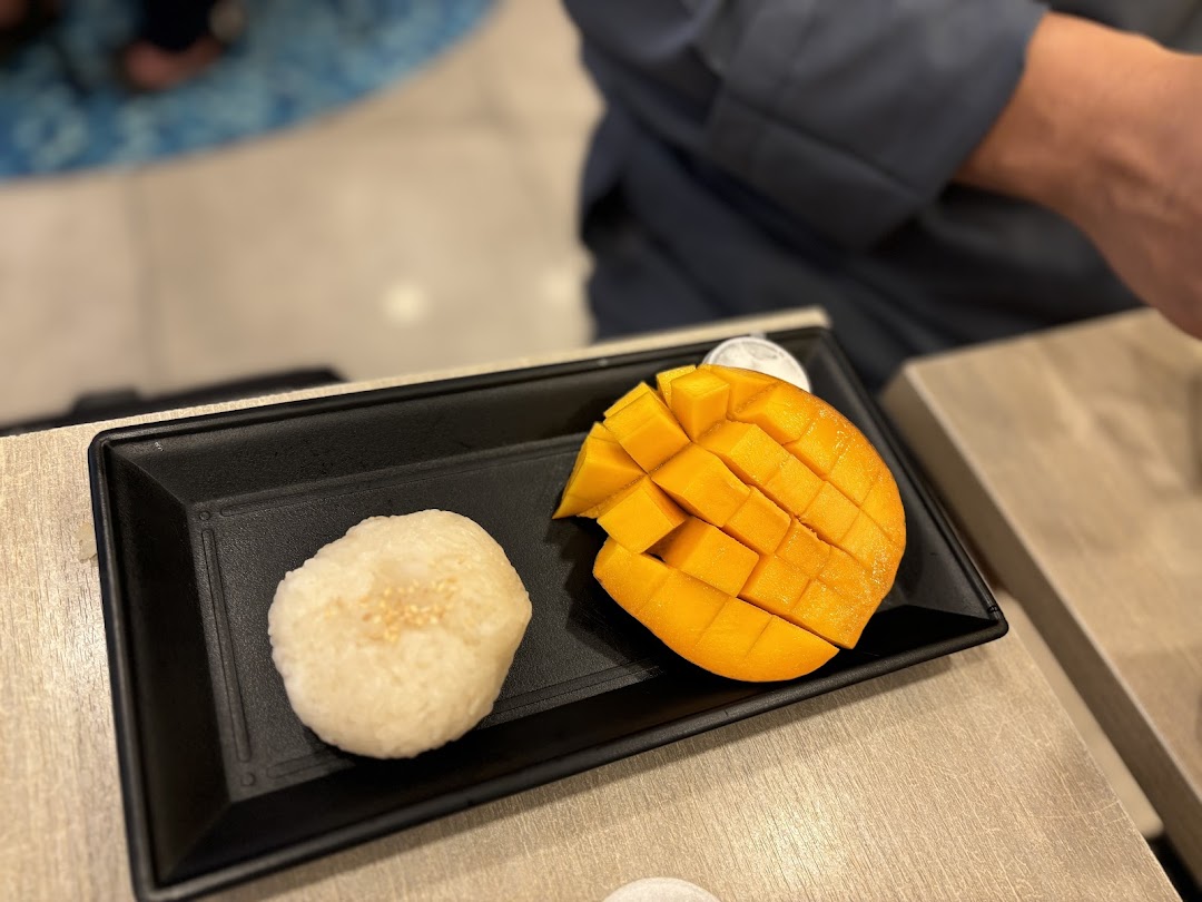 Close-up of mango sticky rice served on a black plate.