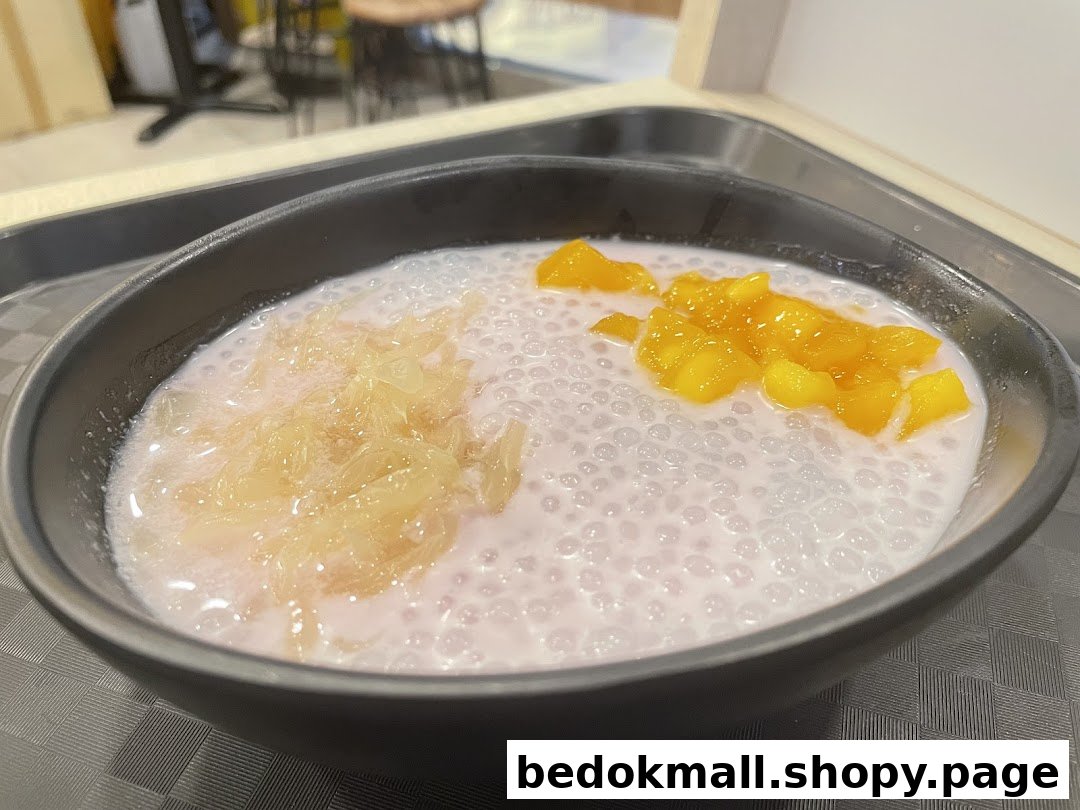A bowl of Thai dessert with tapioca pearls, mango, and pomelo.