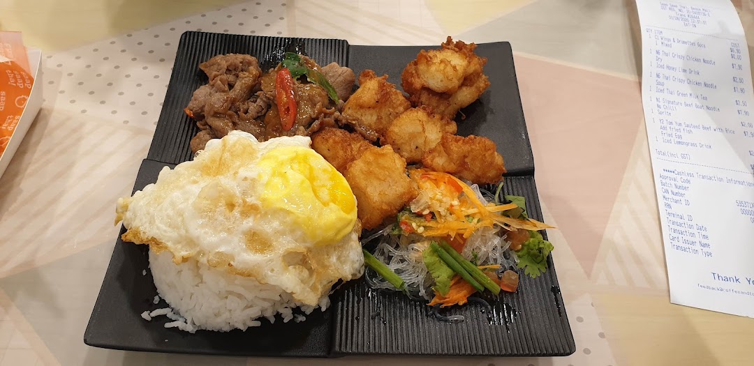 A plate of Thai food with rice, egg, beef, and salad, with a receipt.