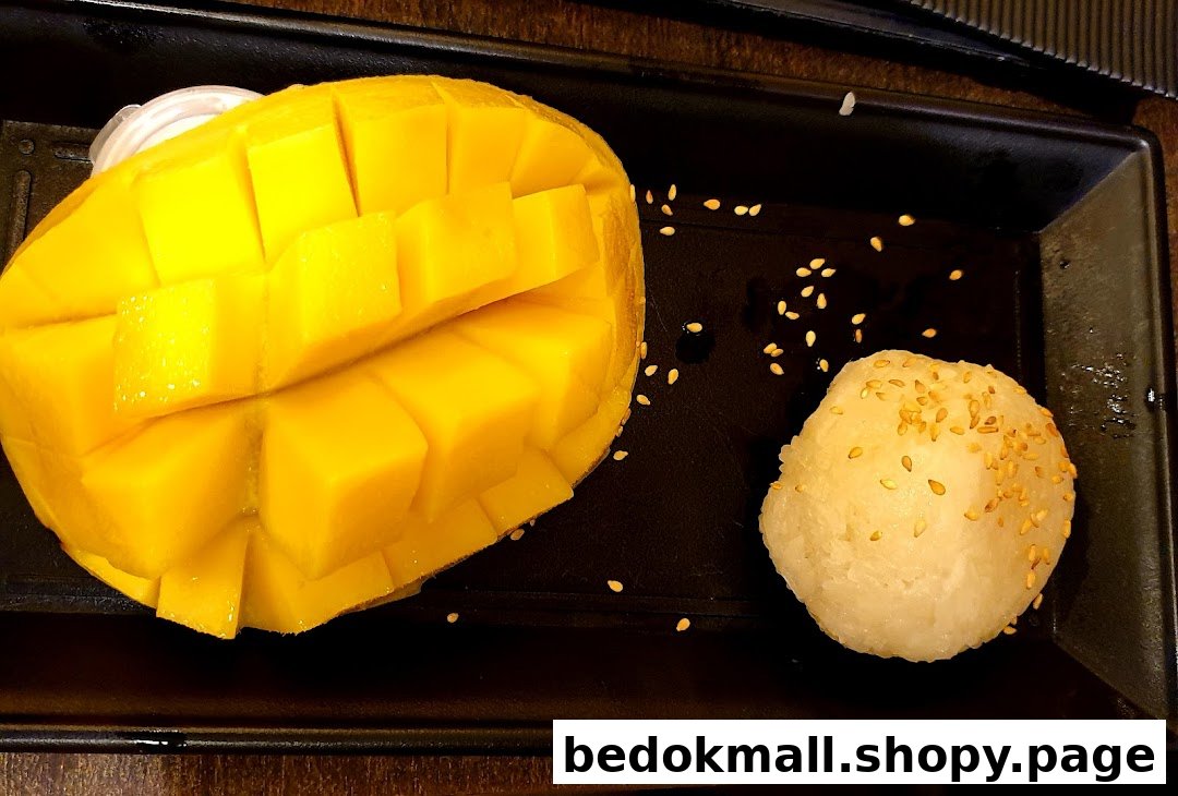 A plate of mango sticky rice dessert with sesame seeds.