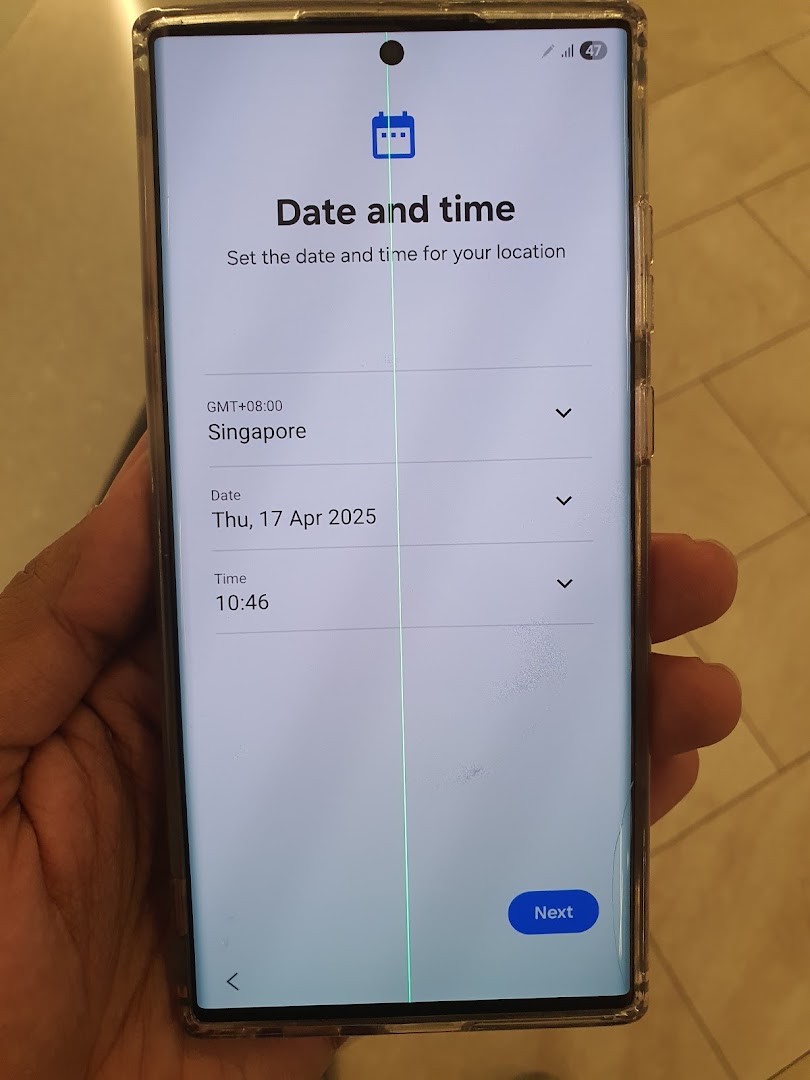 Hand holding a smartphone displaying date and time settings with a green line.