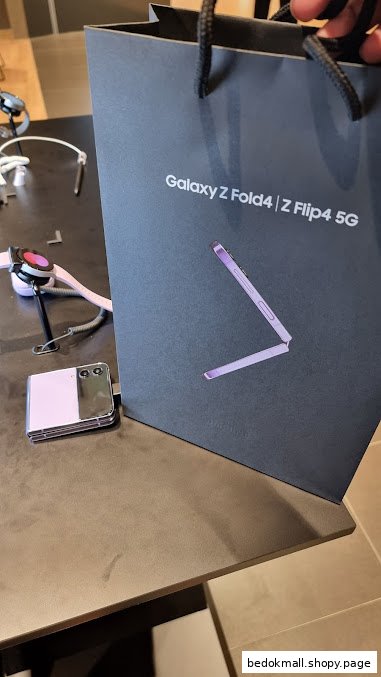 Samsung shopping bag, Z Flip phone, and smartwatch on a display table.