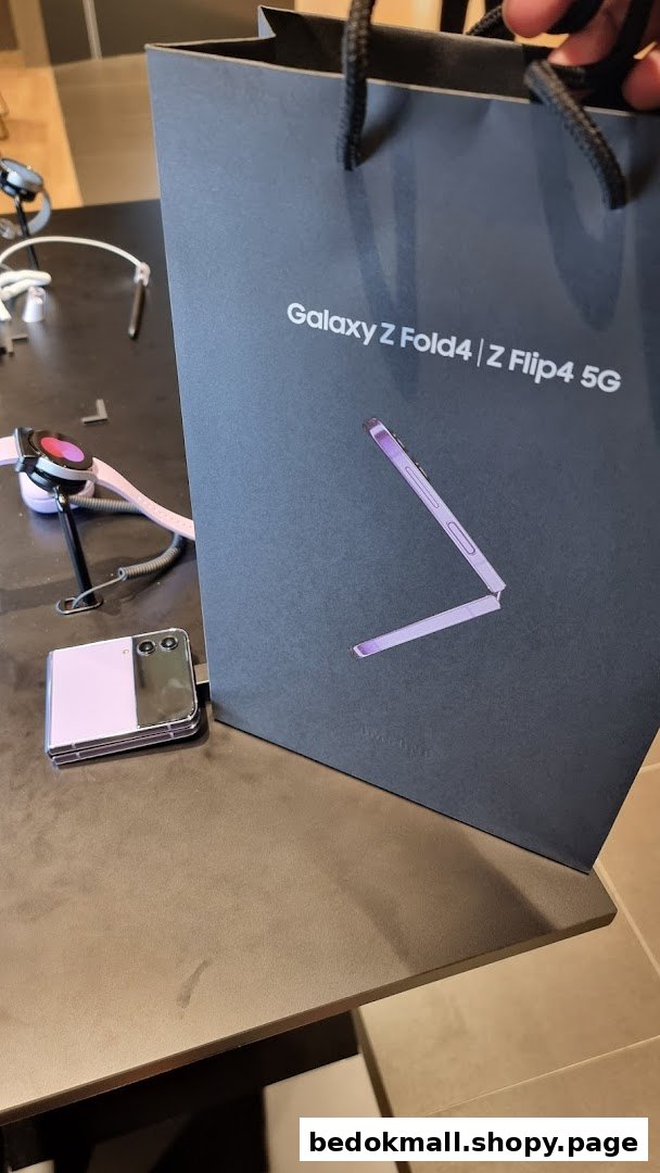 Samsung shopping bag, Z Flip phone, and smartwatch on a display table.