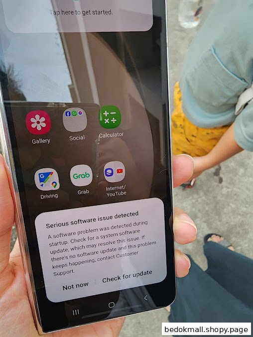 A person holds a Samsung phone displaying a software error message.