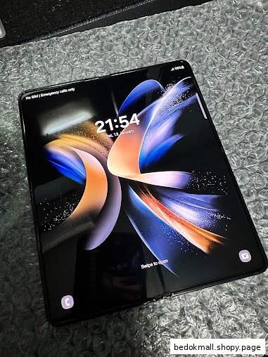 A Samsung foldable phone displaying its lock screen on a textured surface.