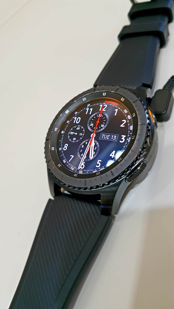 Close-up of a black Samsung smartwatch with a digital display.