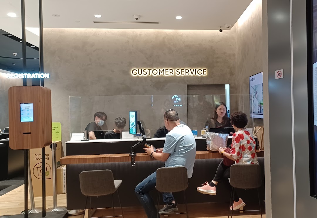 Customers and staff at a Samsung customer service counter.