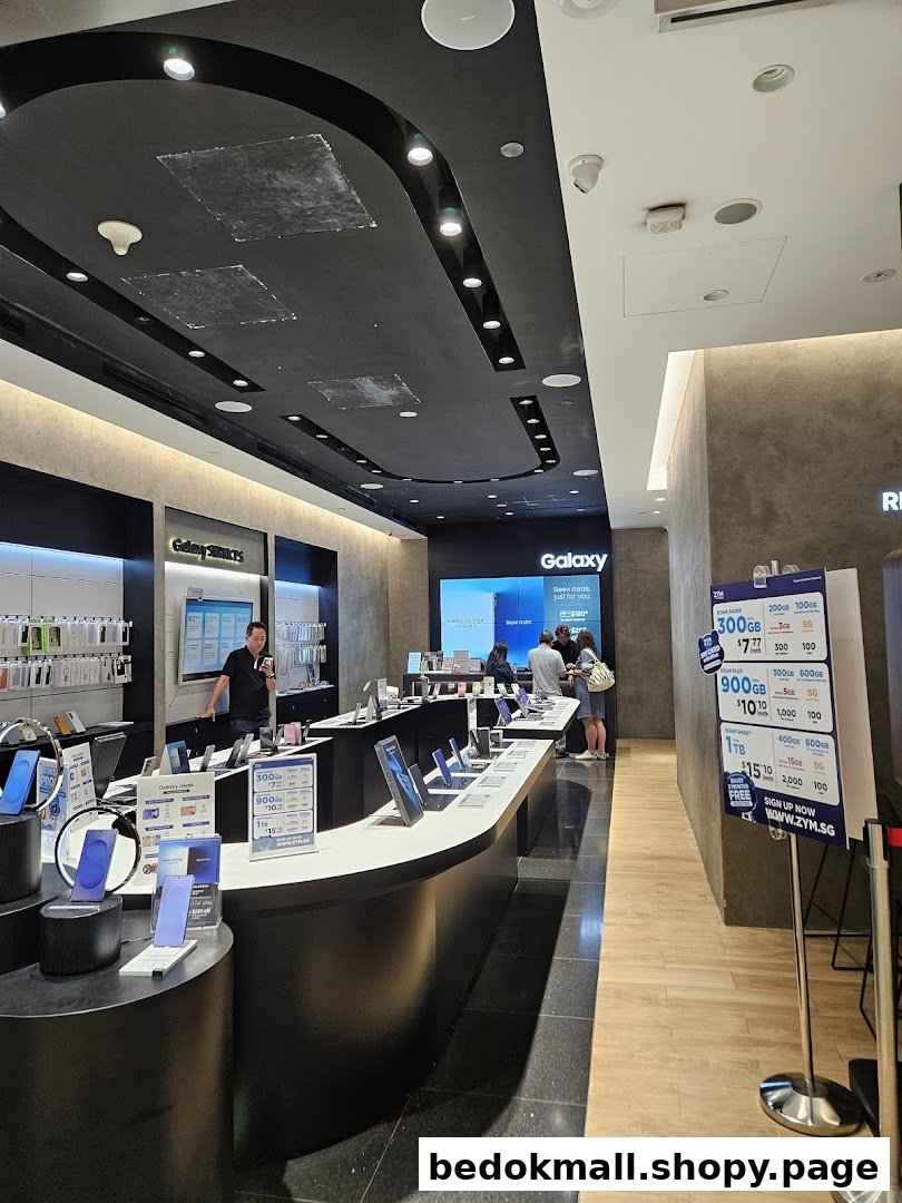 Interior of a Samsung store with display tables, electronic devices, and customers.