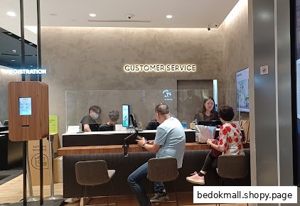 People at a customer service counter with a registration kiosk inside the store.