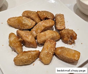 A plate of golden-brown fried food pieces with sesame seeds.