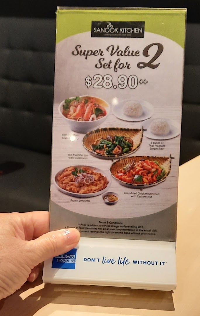 Hand holding a Sanook Kitchen menu displaying food photos and prices.