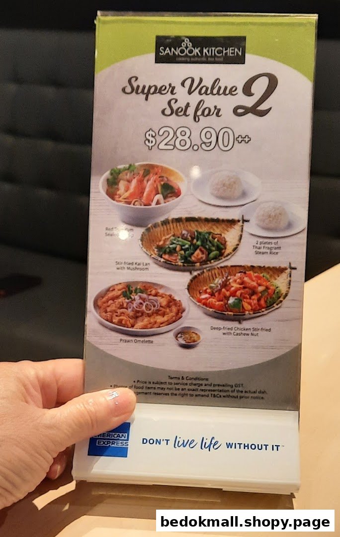 Hand holding a Sanook Kitchen menu displaying food photos and prices.