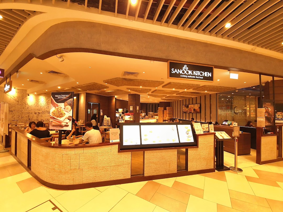 Interior view of Sanook Kitchen restaurant with customers dining and a service counter.