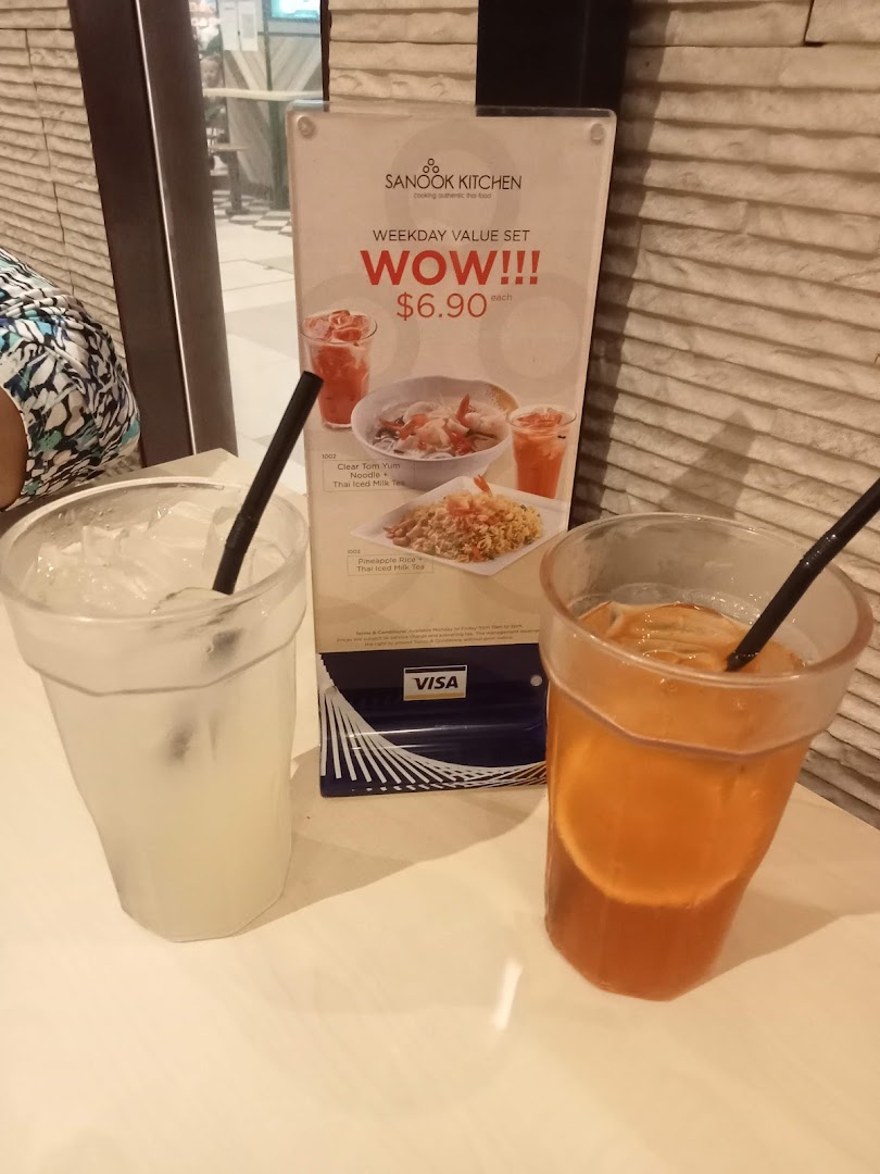 Two drinks on a table with a Sanook Kitchen menu display showing food and prices.