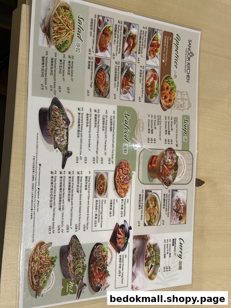 A laminated menu displaying various Thai food dishes with images and prices.