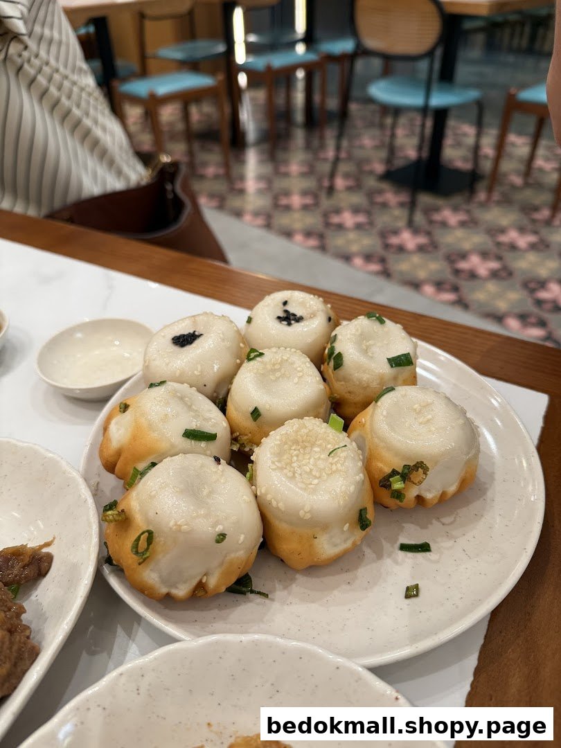 Plate of pan-fried buns with restaurant interior in the background.