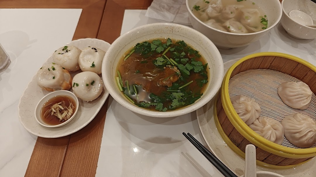 Table with pan-fried buns, soup, and steamed dumplings.