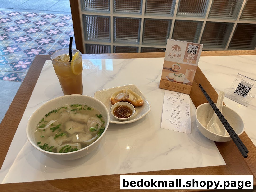 A table with a bowl of soup, pan-fried buns, and a drink.