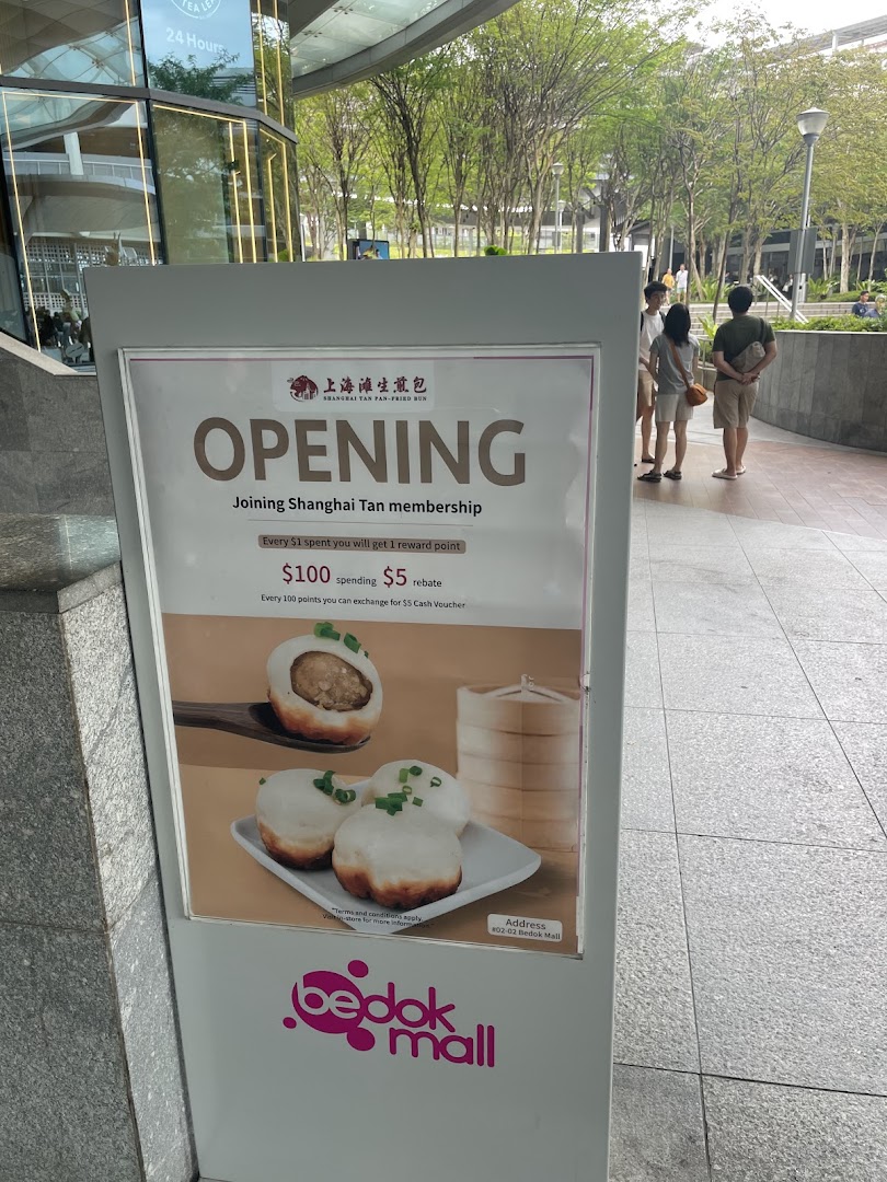 Outdoor promotional sign for Shanghai Tan Pan-Fried Bun with food images.