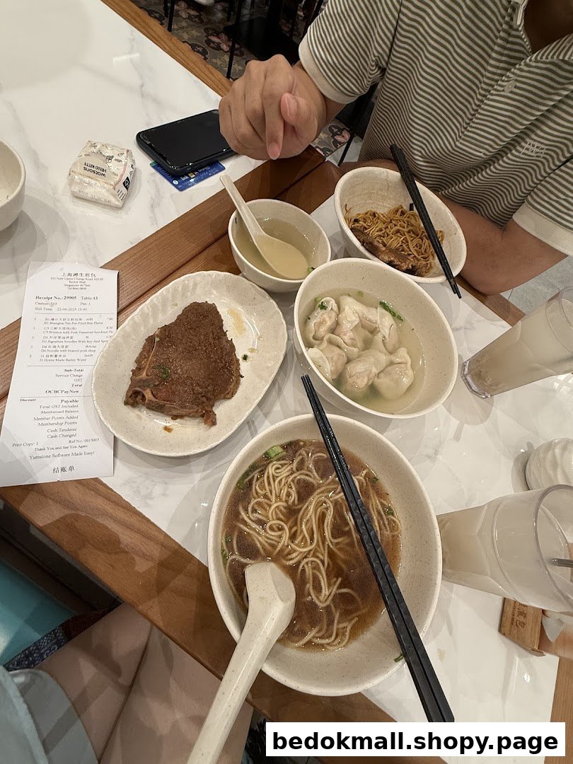 Table with multiple bowls of food, drinks, and a receipt in a restaurant.